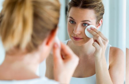 Woman with acne-prone skin cleaning her face