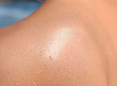 pele feminina descoberta com gotas de água se bronzeando