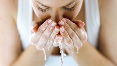 Woman washing her face with water