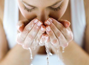 Woman washing her face with water